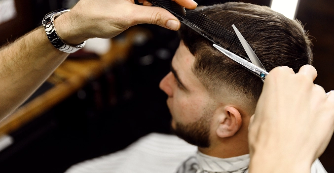 A barber cutting the hair of their client